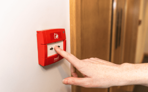 Person Pressing a fire alarm 